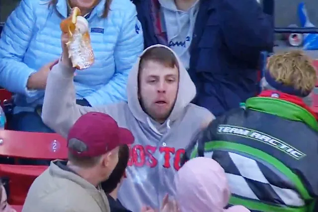A man holding up a funnel cake with a foul ball in it