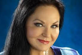 Jax Country 100.3 radio station logo featuring a smiling woman with dark hair.