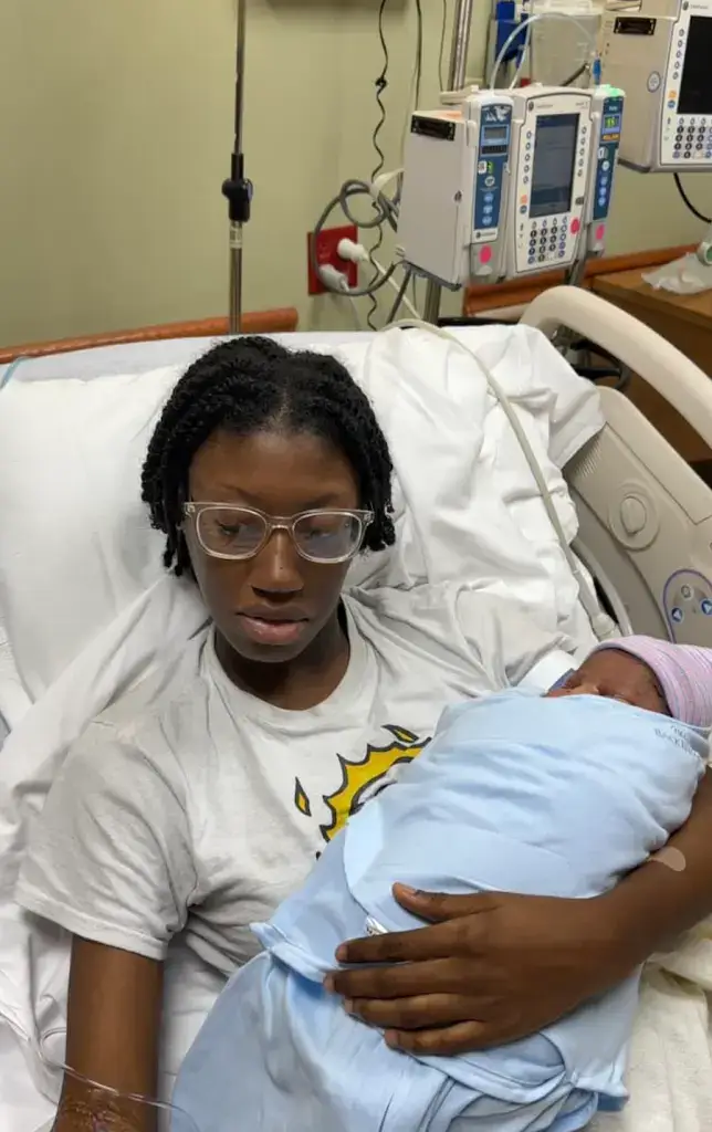 A woman holding a new born baby in a hospital